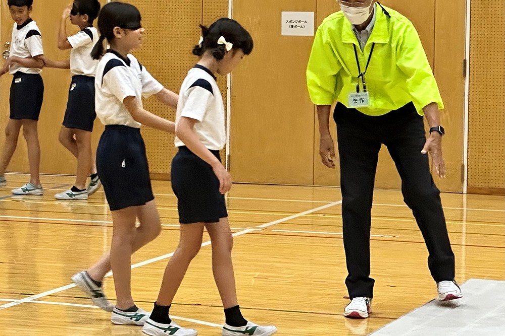 子どもたち同士で介助しながら歩いている写真