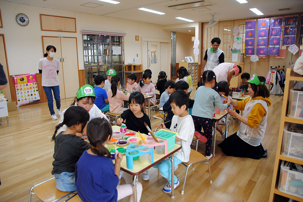 子どもたちがアイスクリームの見本に色を塗っている写真