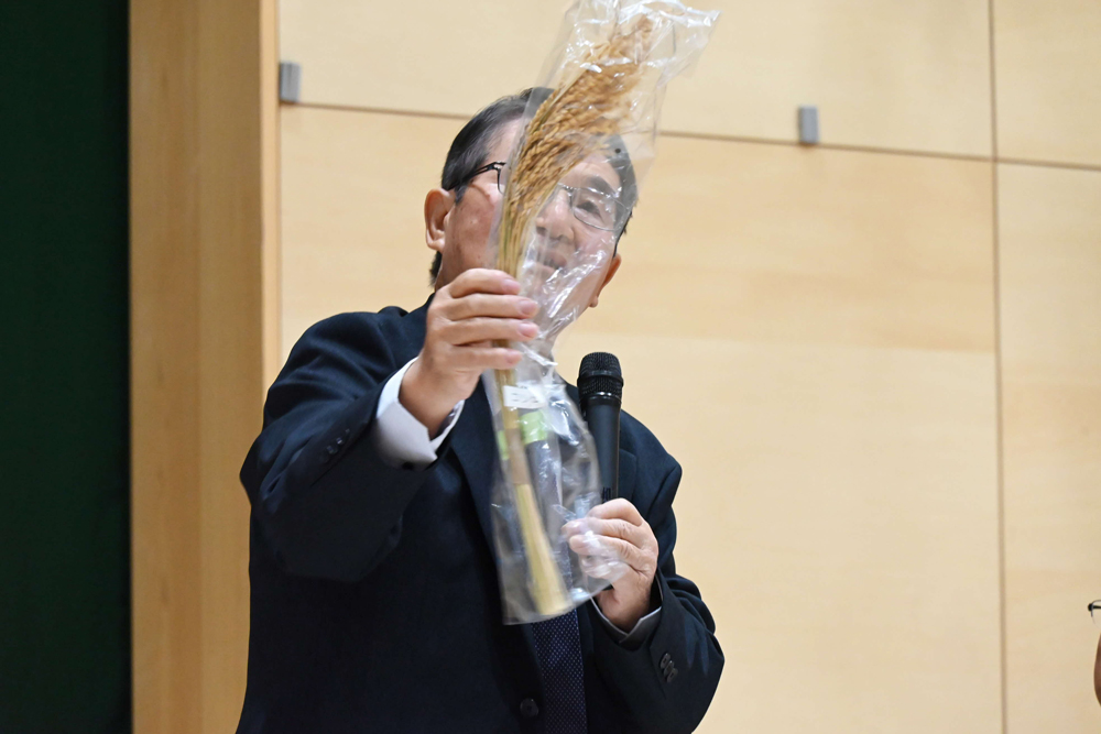 講師の人が稲を持っている様子の写真