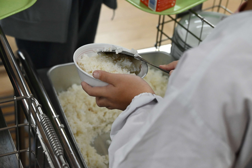 給食で坂井市産のお米をよそっている様子の写真