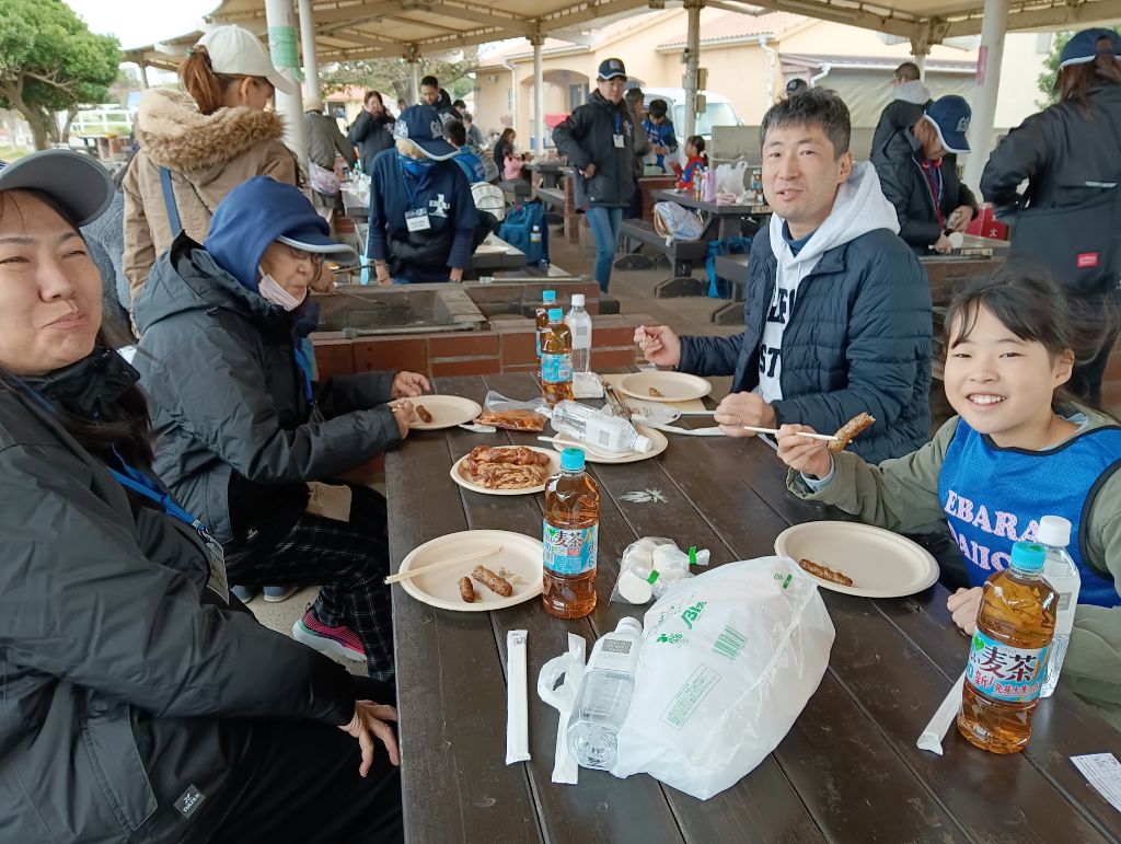笑顔で食事を楽しんでいる親子の画像