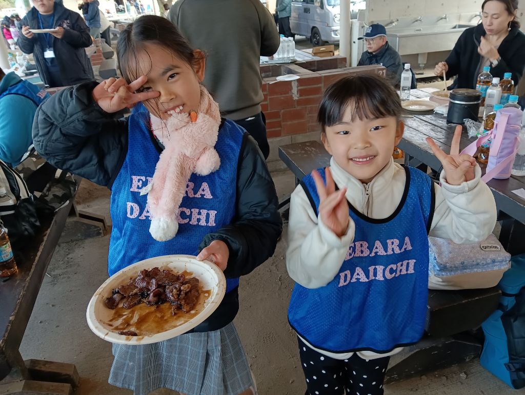 お肉を持ってピースしている女の子の画像