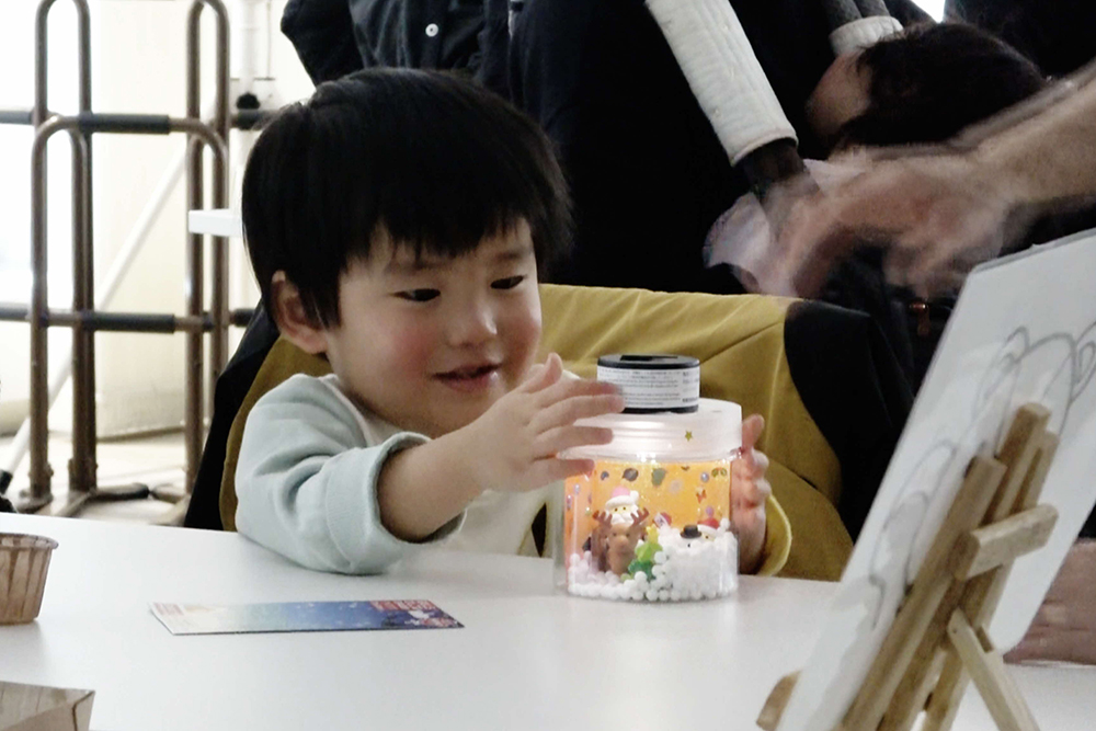 笑顔で完成したランタンを見ている子どもの写真