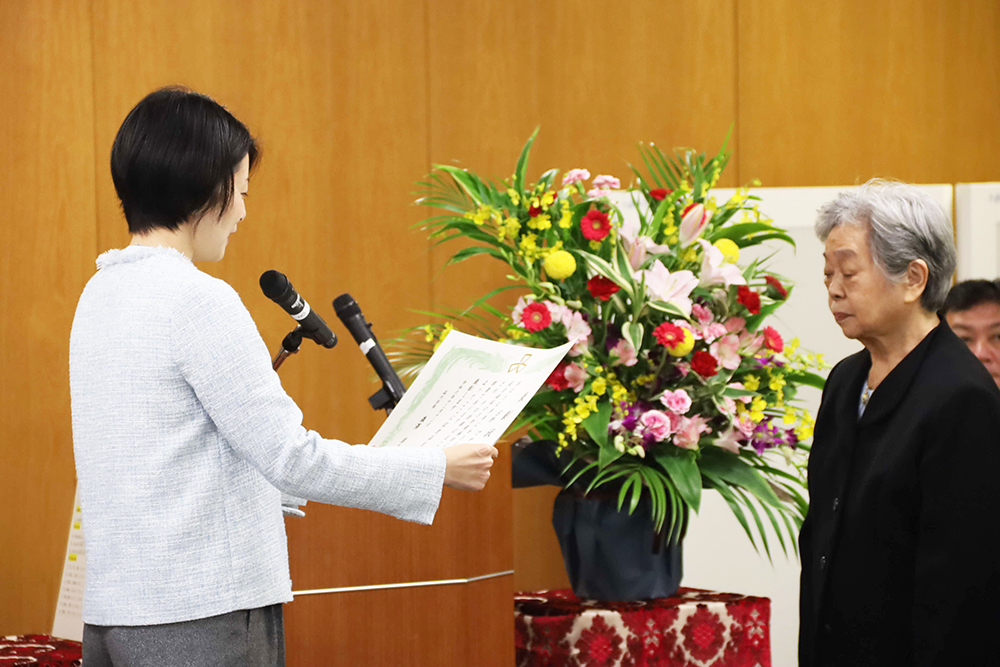 表彰状を読み上げる森澤区長と受賞者の画像
