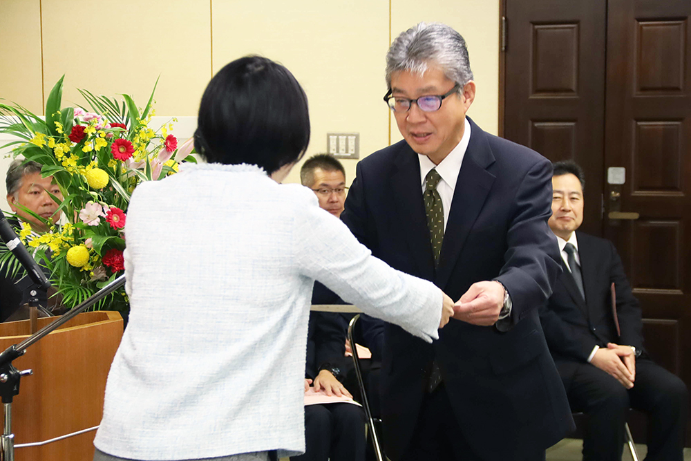 表彰状を受け取る受賞者の画像