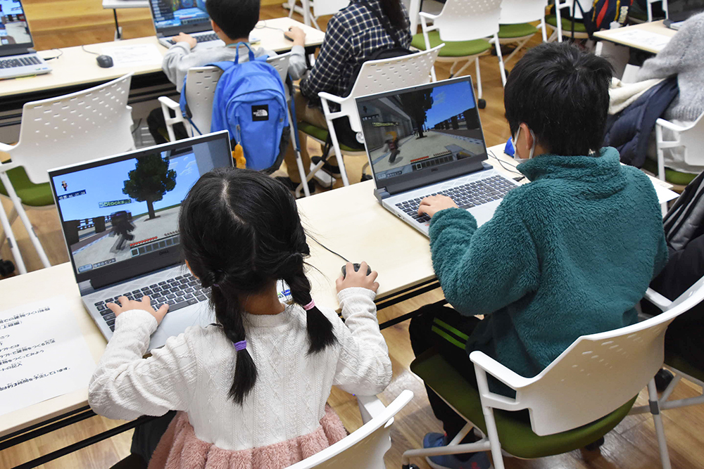 パソコンを操作し制作する子どもの画像