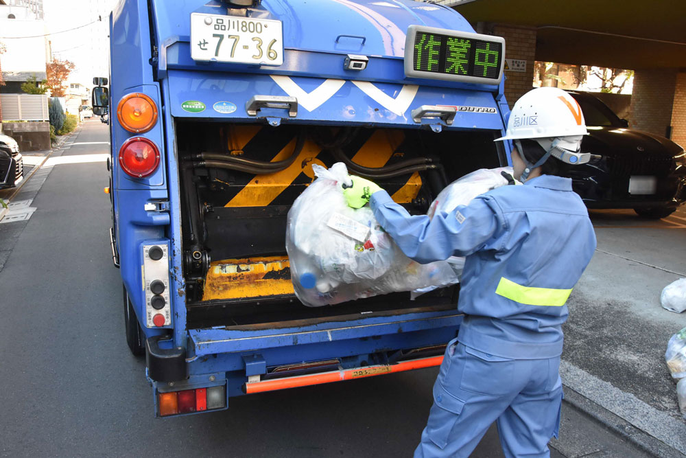 ごみをごみ収集車に入れいる様子の写真