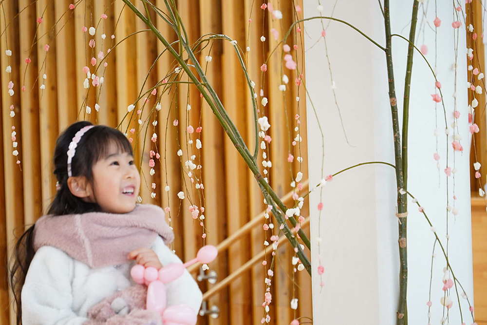 子どもが餅花を眺めている写真