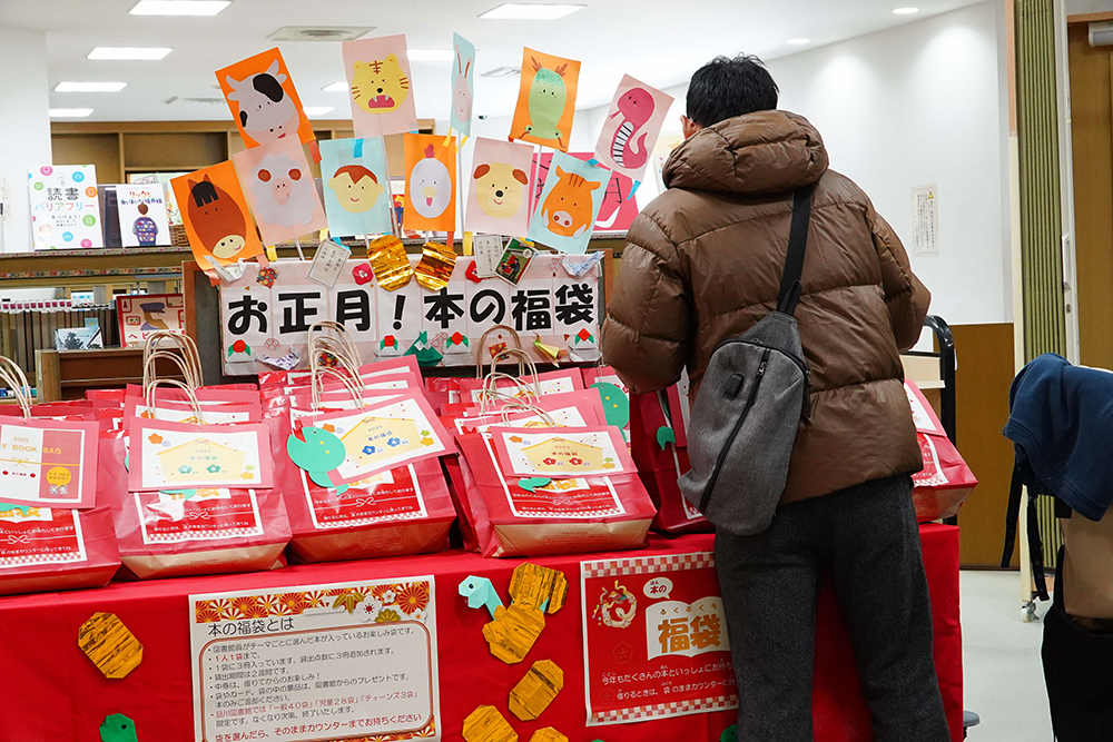 男性が本の福袋を選んでいる写真