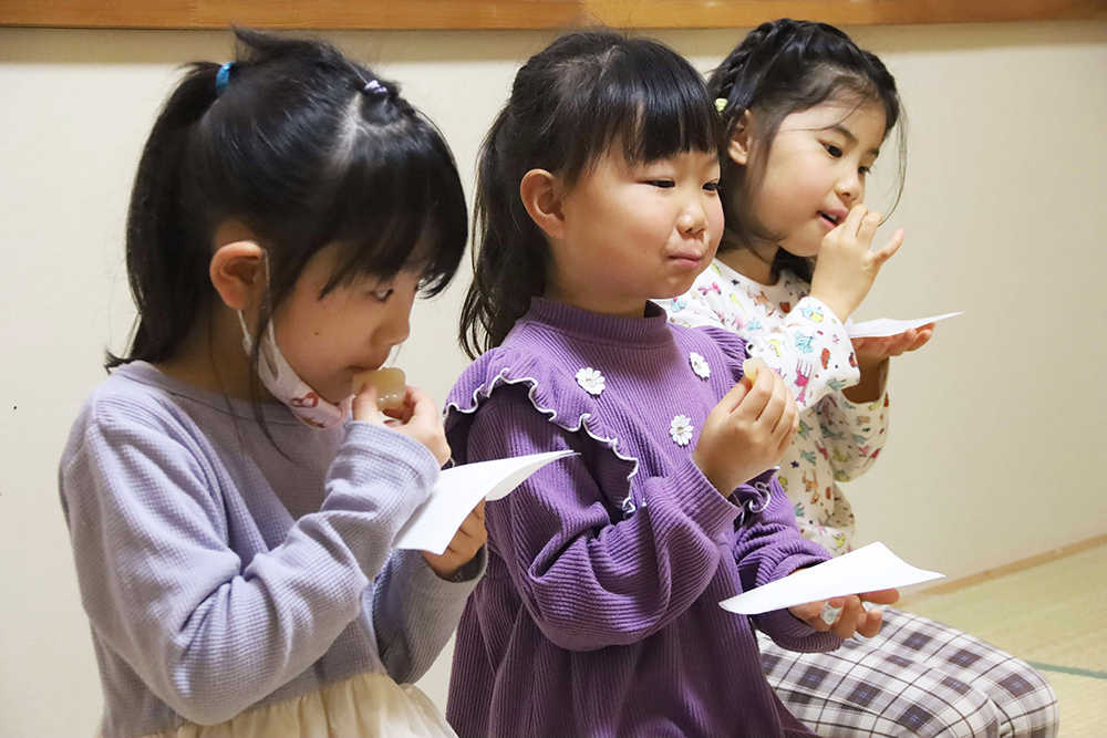 お菓子を食べる子どもたちの画像