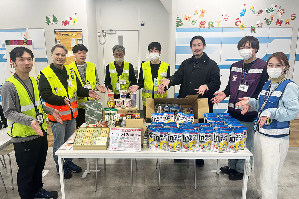 届けられた多くの食品と関係者の写真
