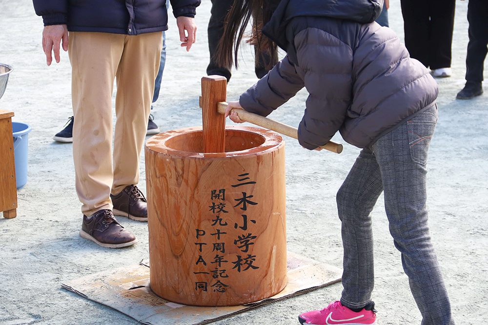 PTAから寄贈された臼ともちつきをする児童の画像