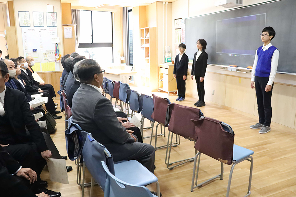 研究発表する児童と話を聞く参加者の画像