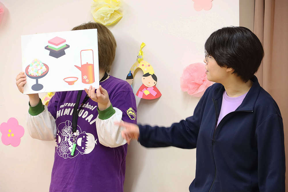 ひな祭りについて説明する保育士の画像