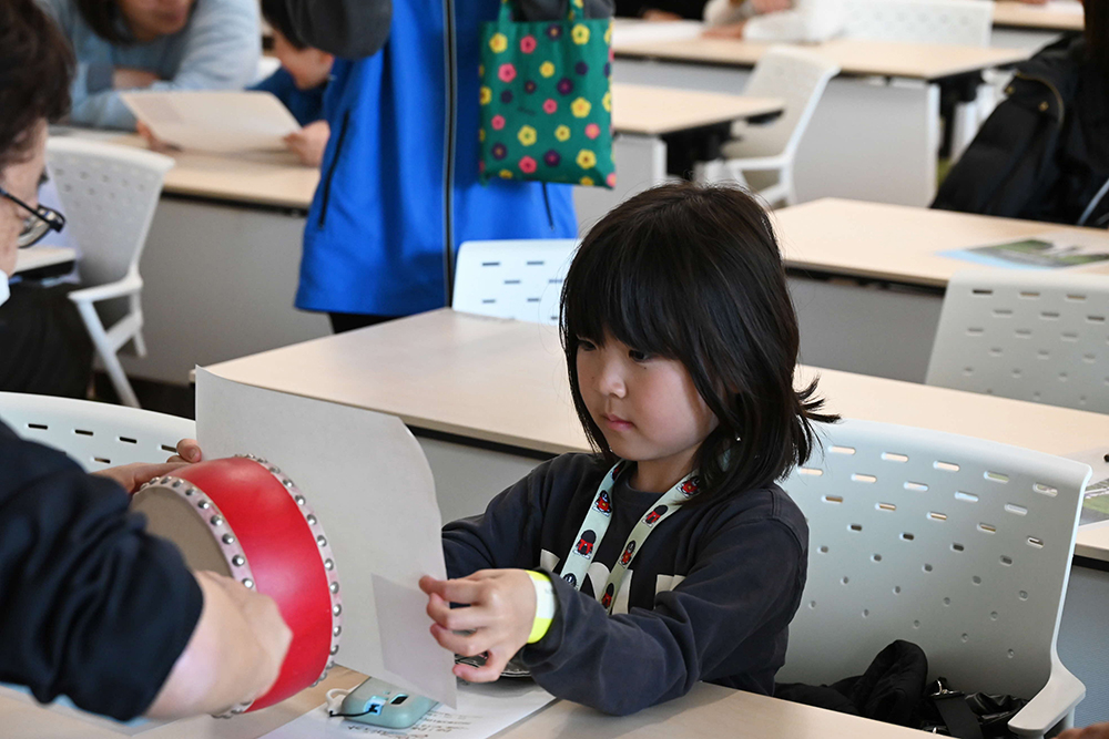 音の仕組みを体験する子どもの画像