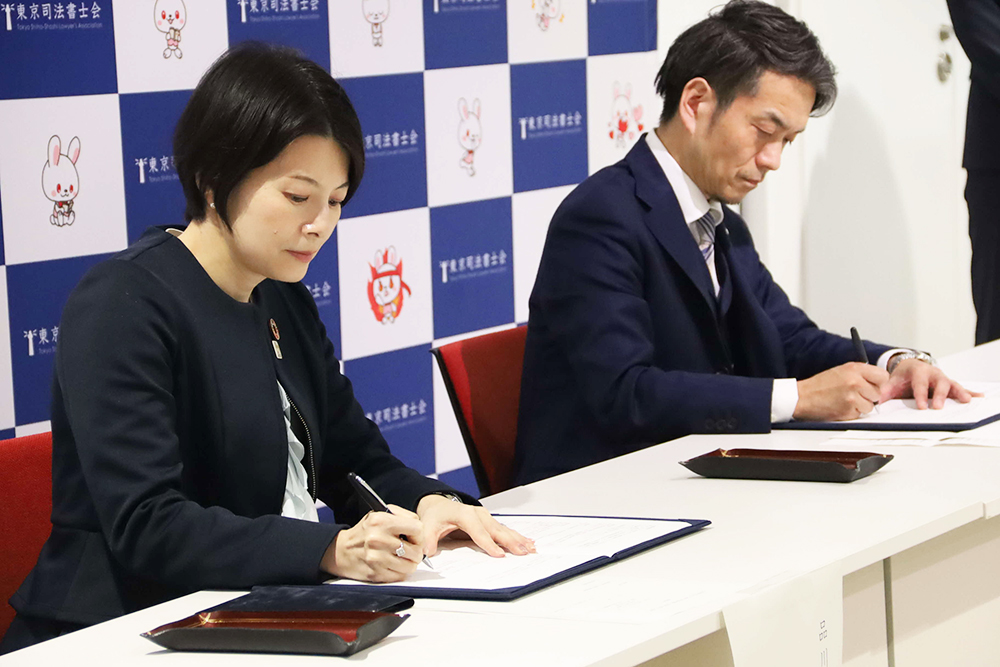 署名する森澤区長と千野会長の画像
