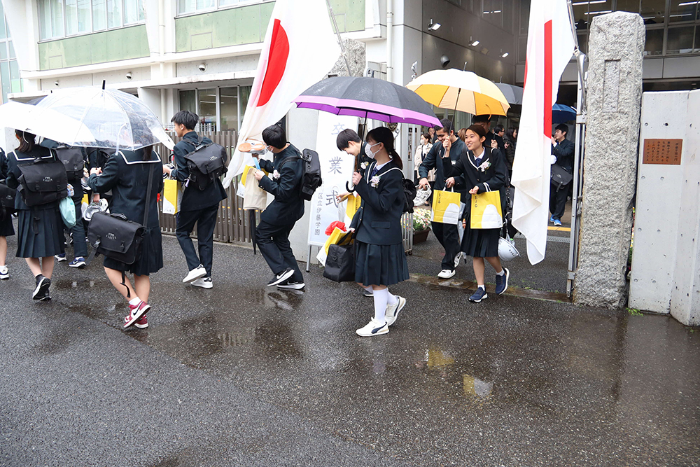 伊藤門から出る卒業生たちの画像