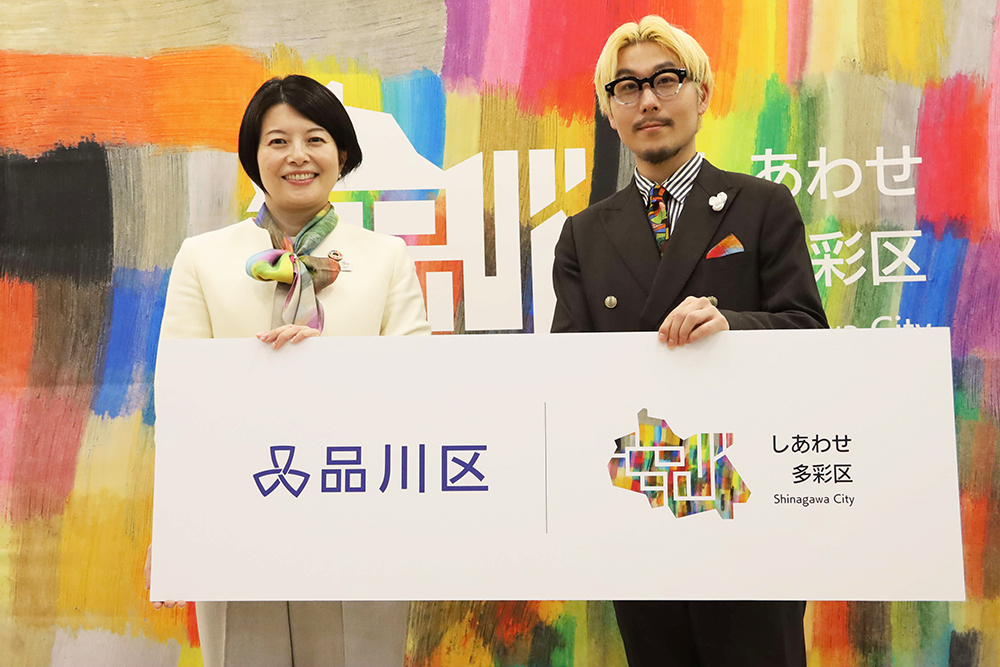 ボードの前で写真撮影する区長・松田さんの画像