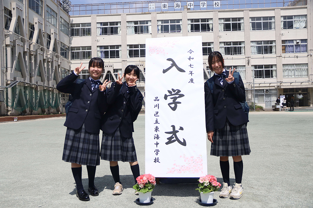 校舎をバックに記念撮影する7年生の画像