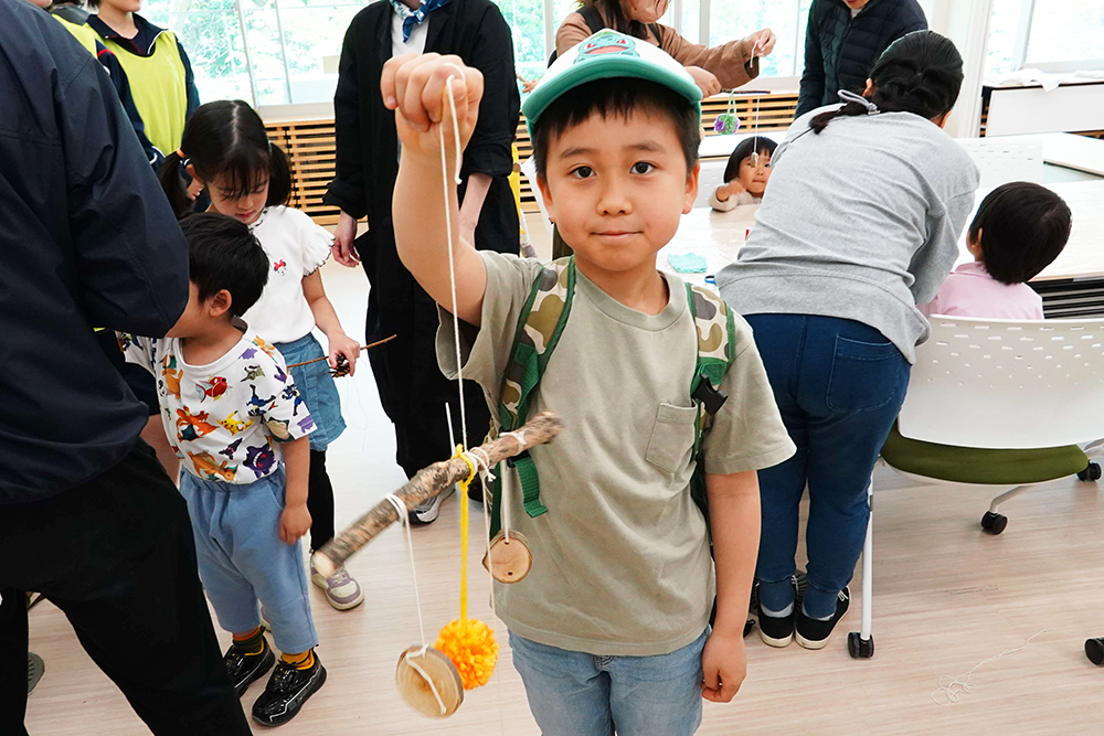 木のモビールを作成した子どもの画像