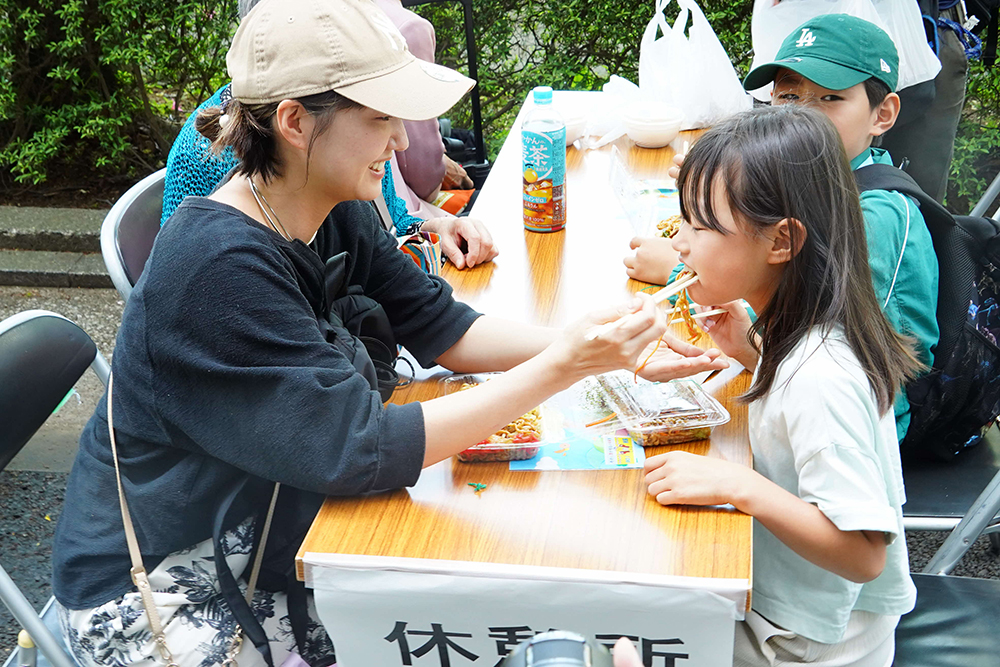 焼きそばを食べる親子の写真