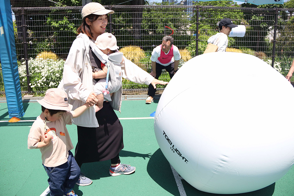 大玉ころがしで遊ぶ親子の画像