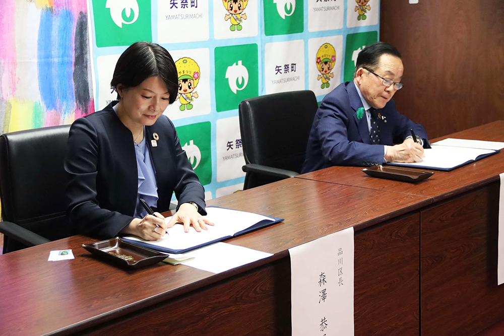 サインする森澤区長と佐川町長の画像