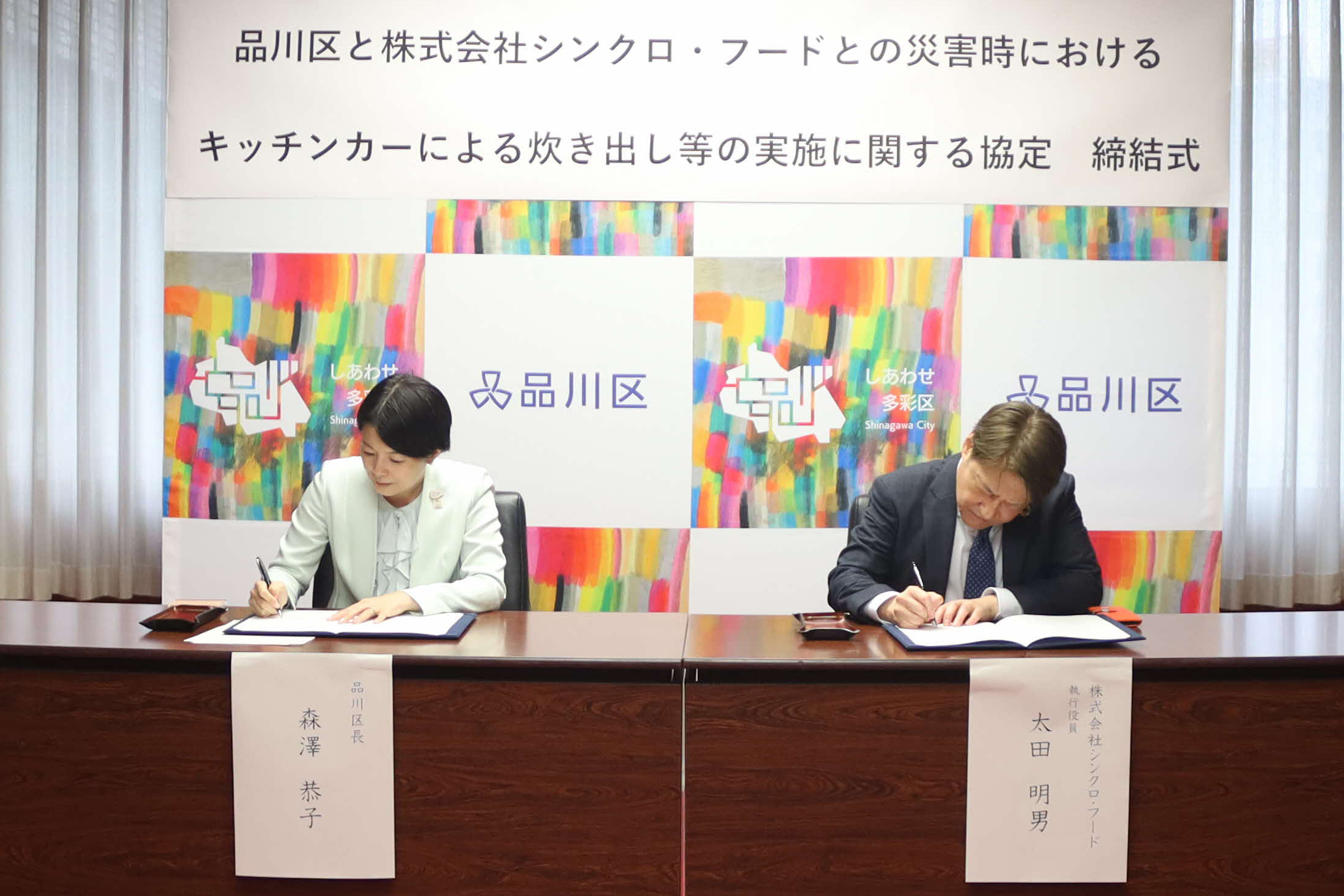 署名をする森澤区長と太田執行役員の画像