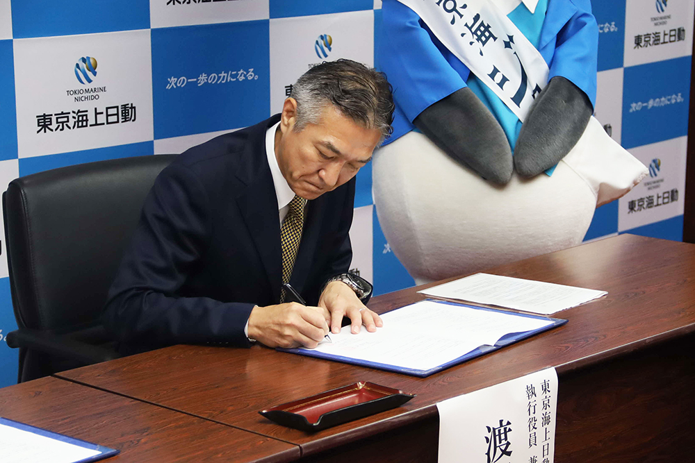 協定書に署名をする渡部執行役員の画像