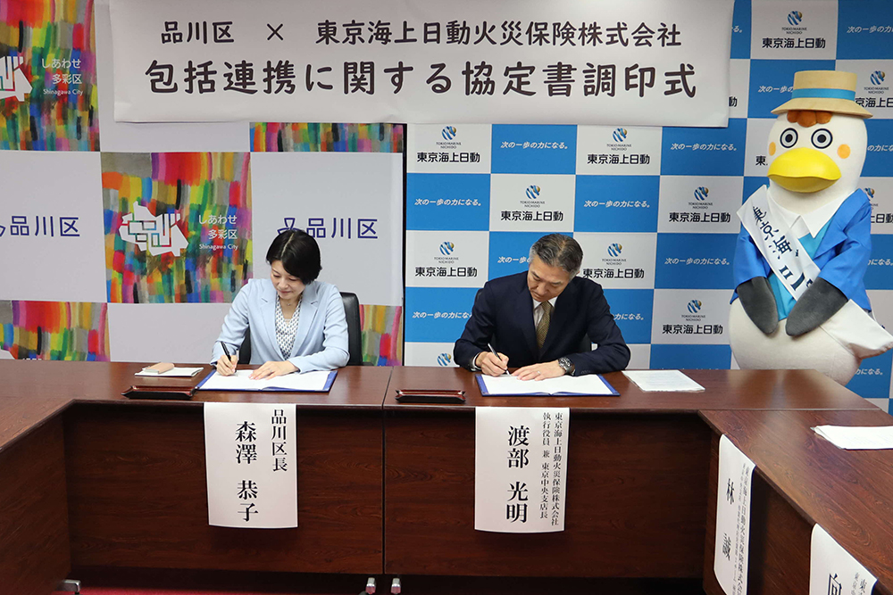 協定書に署名をする森澤区長と渡部執行役員の画像