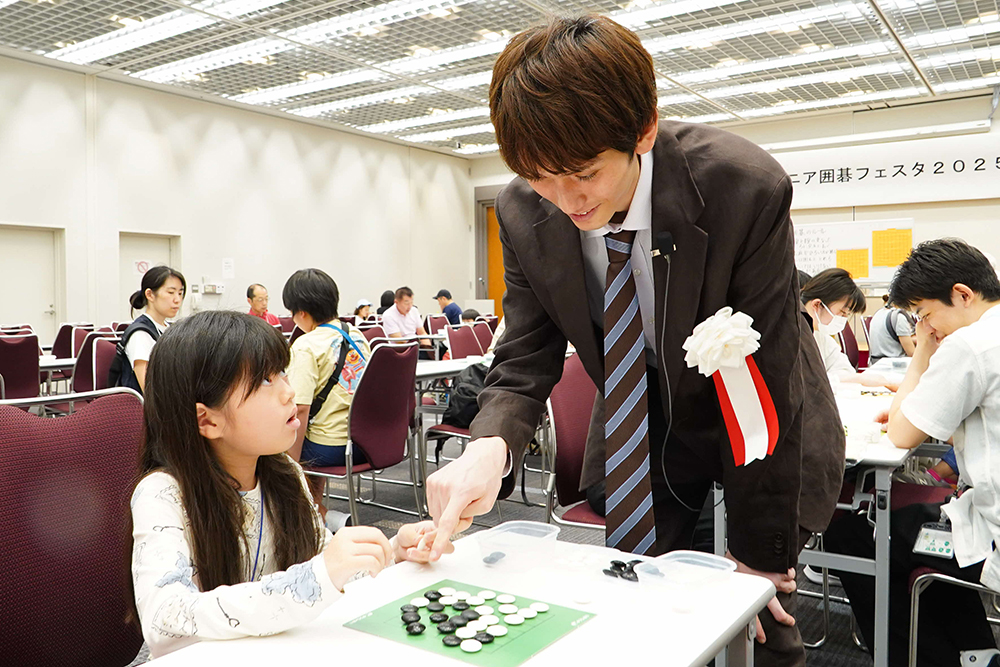 プロ棋士に指導を受ける参加者の画像
