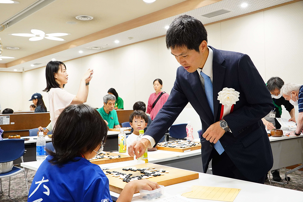 参加者とプロ棋士が対局する画像