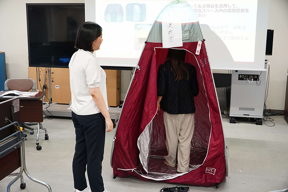 簡易更衣室を体験する参加者の写真