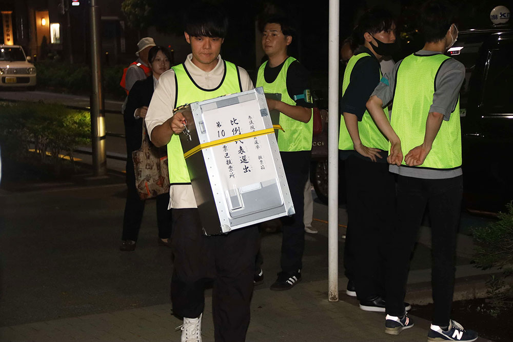 投票箱を荷卸す職員の写真