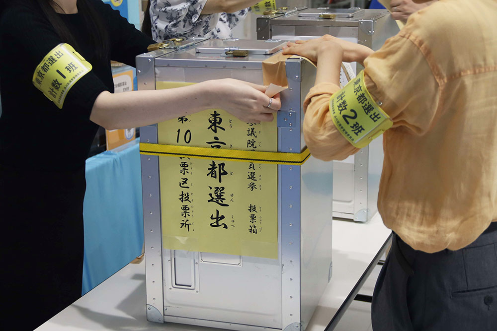 投票箱の受け渡しを行う職員の写真