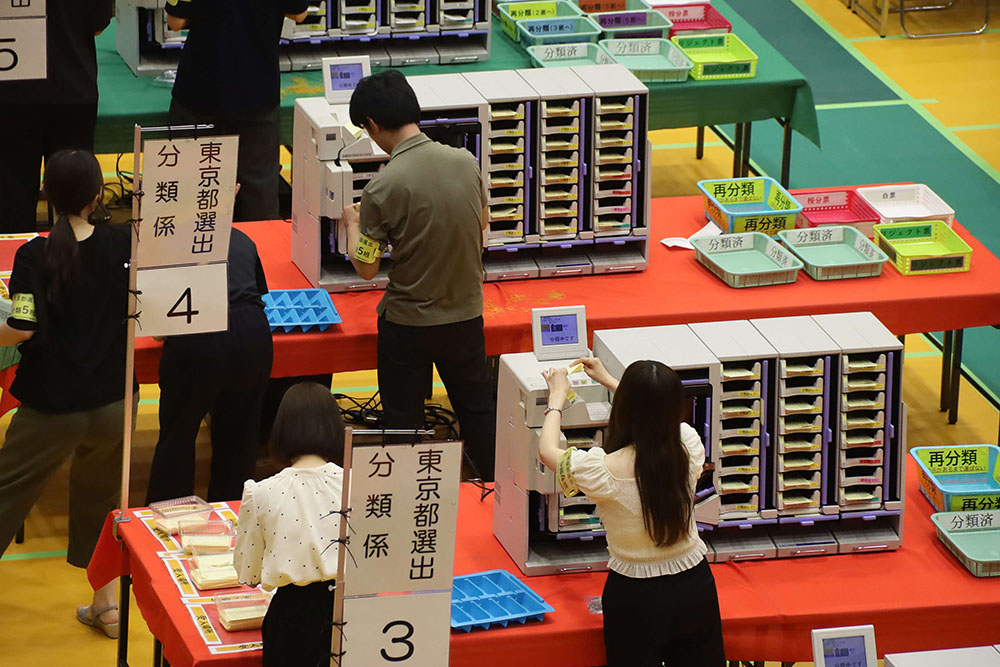 票を分類する職員の写真