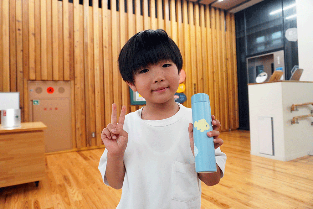 完成したマイボトルと記念撮影する子どもの写真
