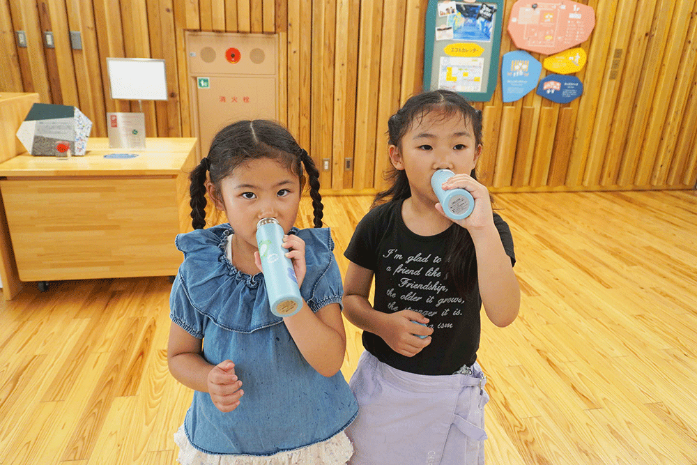 作ったマイボトルで飲料している子どもたちの写真