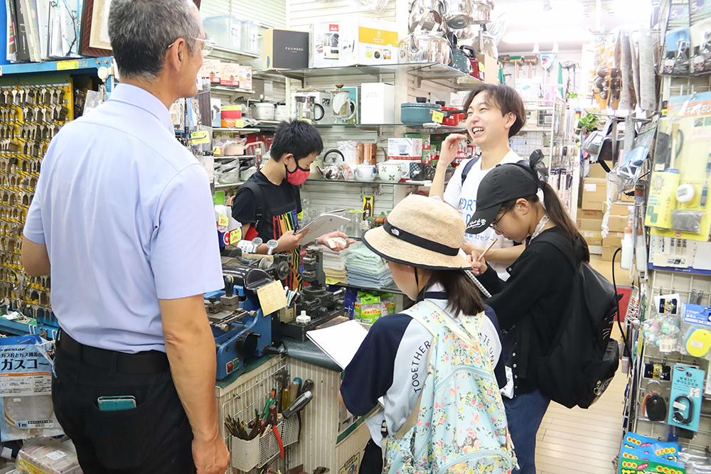 金物屋で話を聞く子どもたちの画像