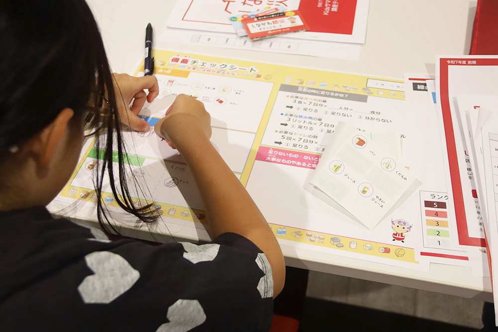 備蓄ノートに書きこむ子どもの画像