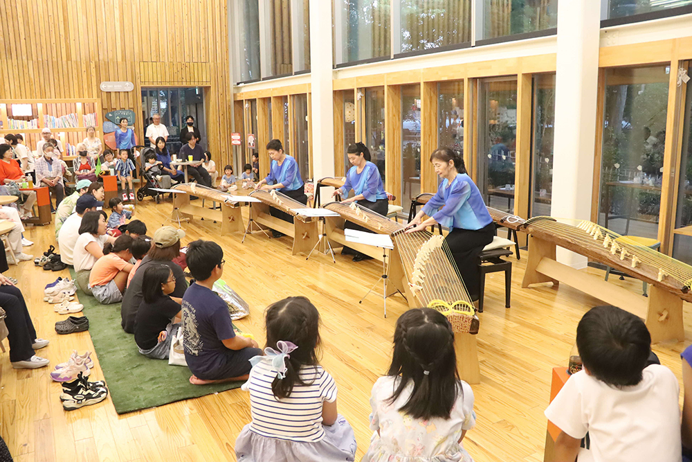 箏演奏者と観客の画像