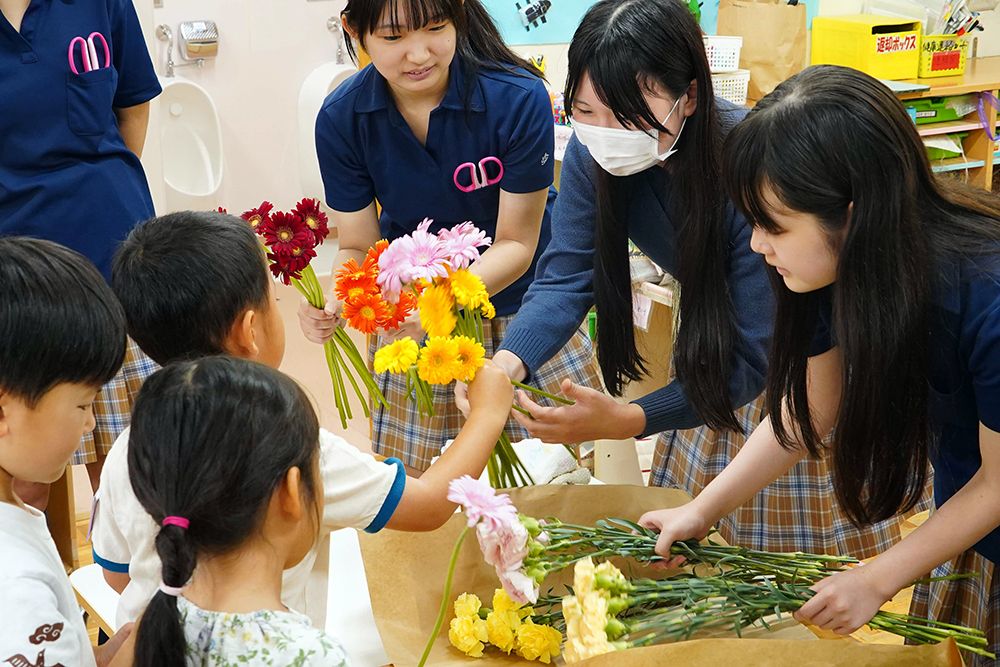 園児にアレンジする花を渡している写真