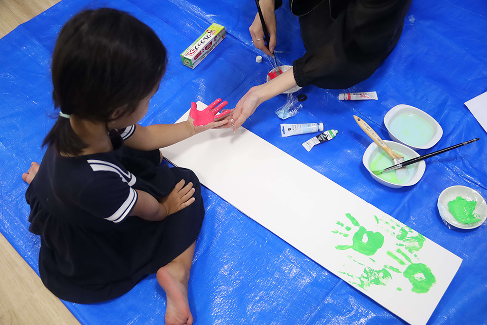 クラフト体験で手形を押す子どもの画像