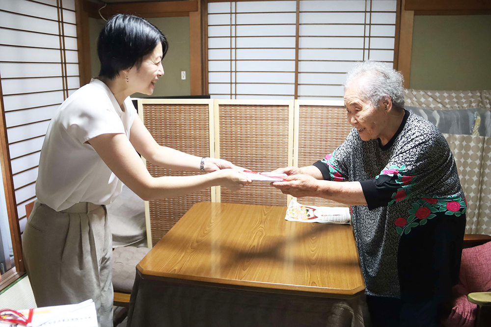 露雪さんにお祝い品を手渡す森澤区長の画像