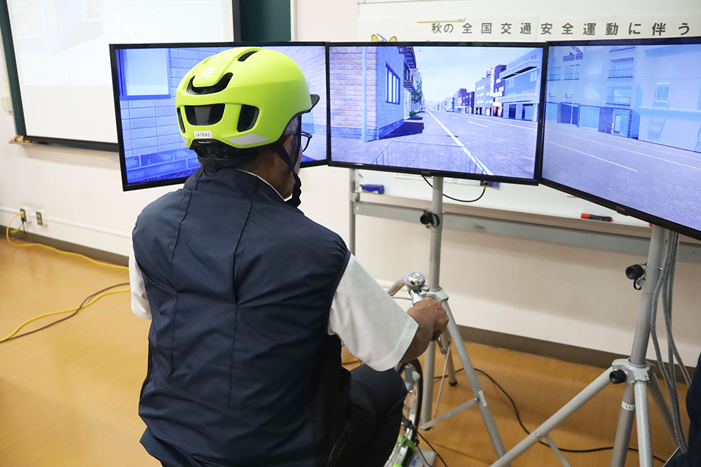 自転車シミュレーターを体験する参加者の後ろ姿の画像