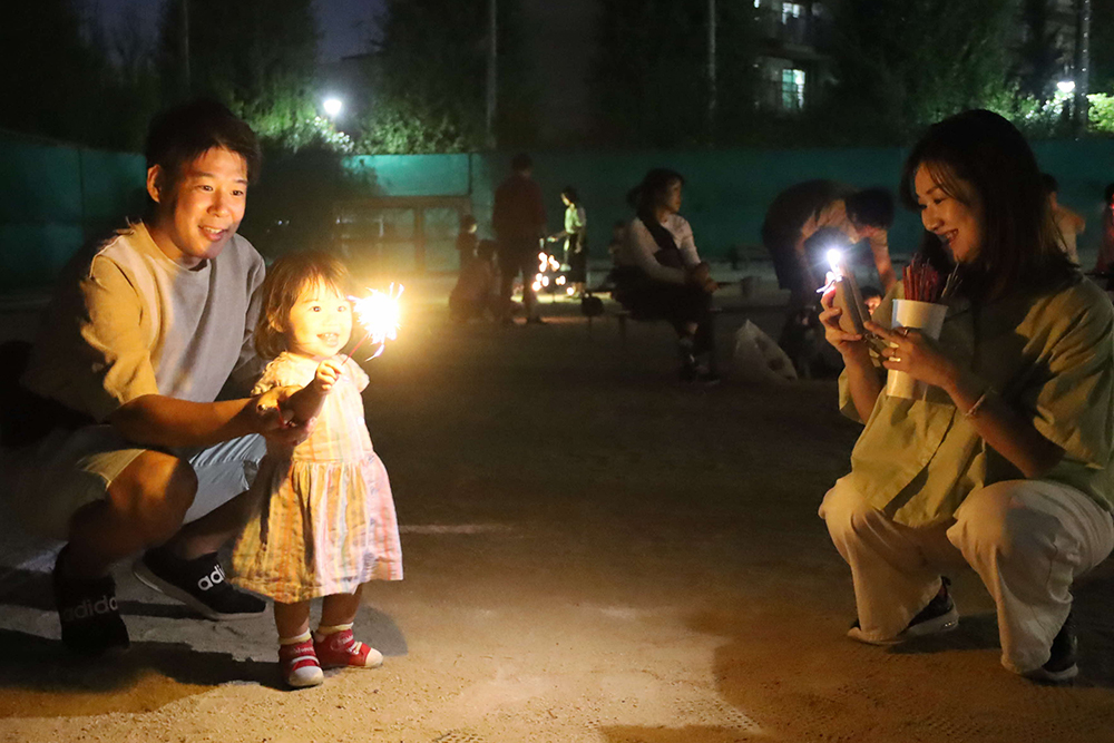 花火を楽しむ親子の画像