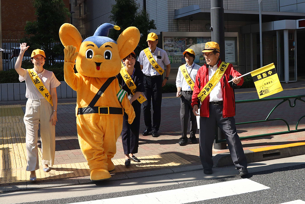 横断歩道を渡る森澤区長とピーポ君の画像