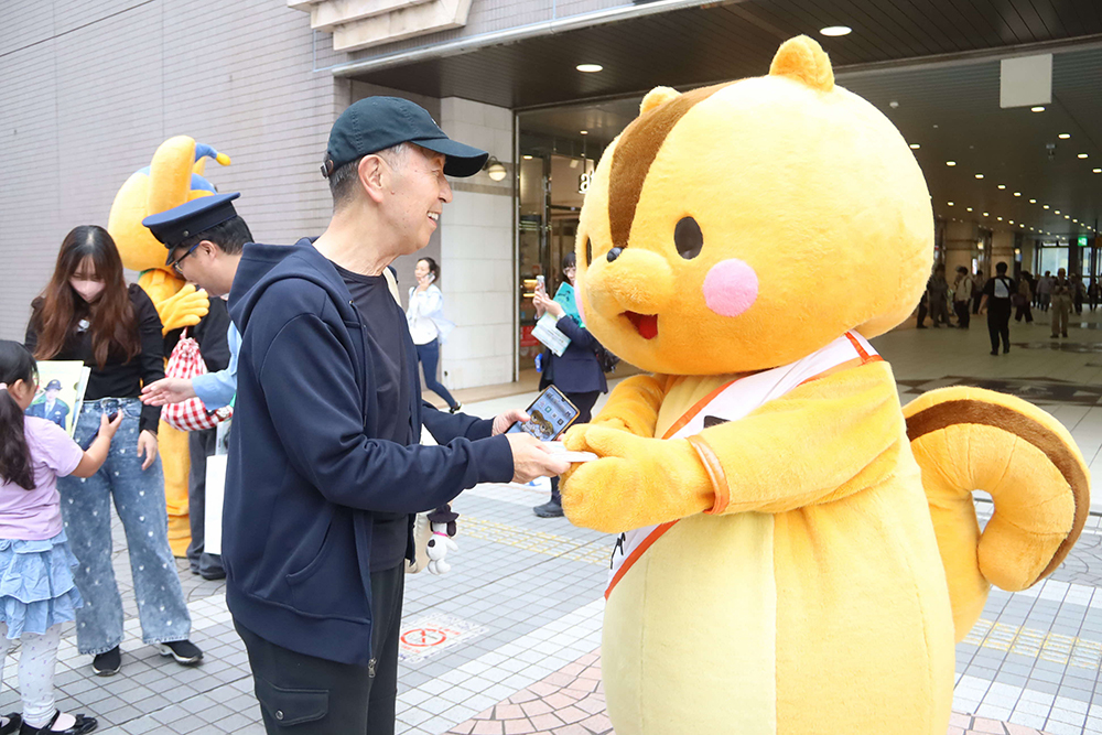 くるみちゃんが啓発グッズを配る画像