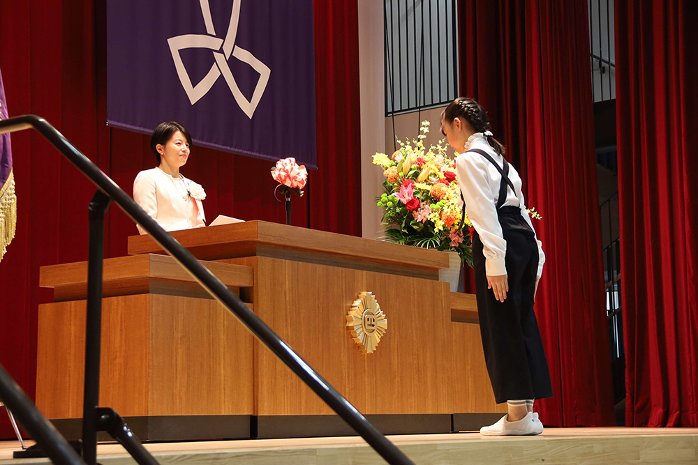 森澤区長が代表児童に記念品を贈呈している写真