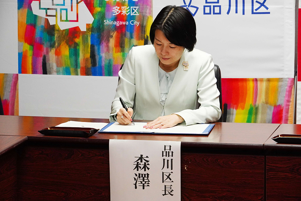 協定書に署名する森澤区長の写真